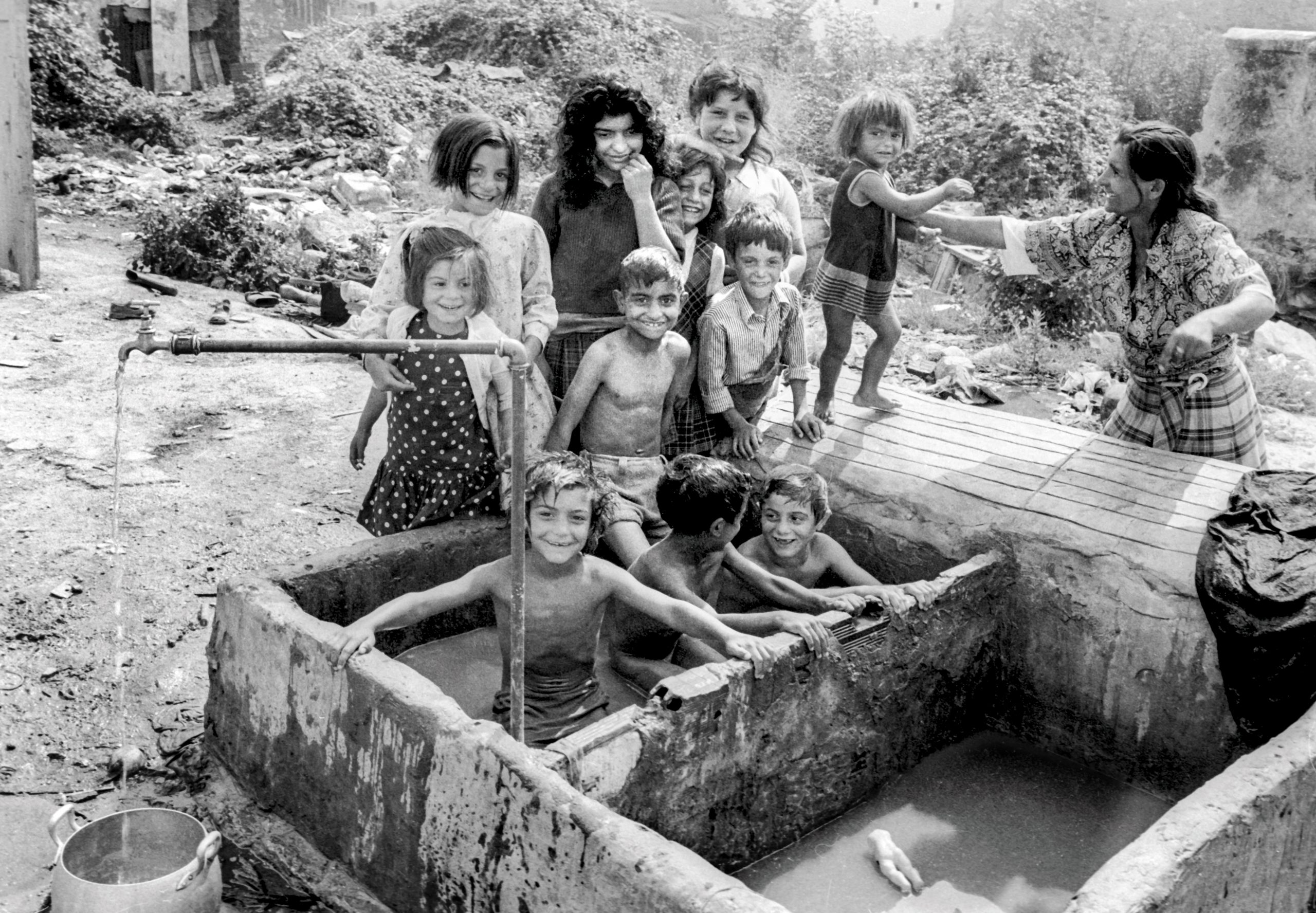 Chavolas de A Cubela, en el corazón de A Coruña. Niños bañándose en un pilón de lavar la ropa.