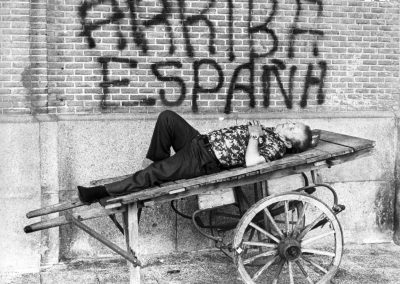Un hombre descansa en un carro ante una pintada de «Arriba España». Madrid, mayo 1979